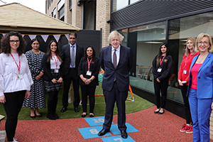 Boris Johnson stood outside Monkey Puzzle Nursery with staff