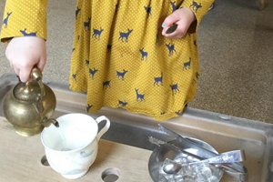 child at Little Angels Nursery playing with tea set