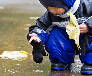 child playing in puddle