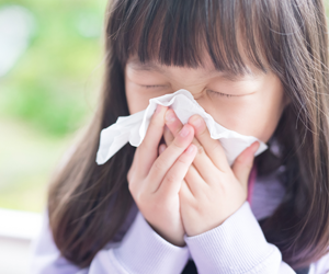 child sneezing in to a tissue