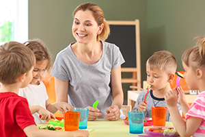 children and smiling practitioner eating their snack or lunch food