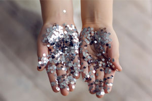 child's hands holding silver glitter