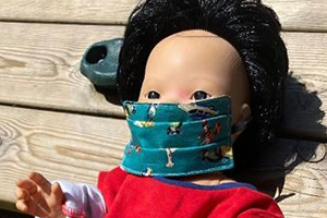 doll with mask on at simon house nursery