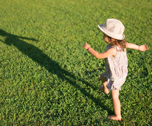 little girl playing with her shadow in the sunshine