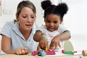 practitioner watching child play with playdough