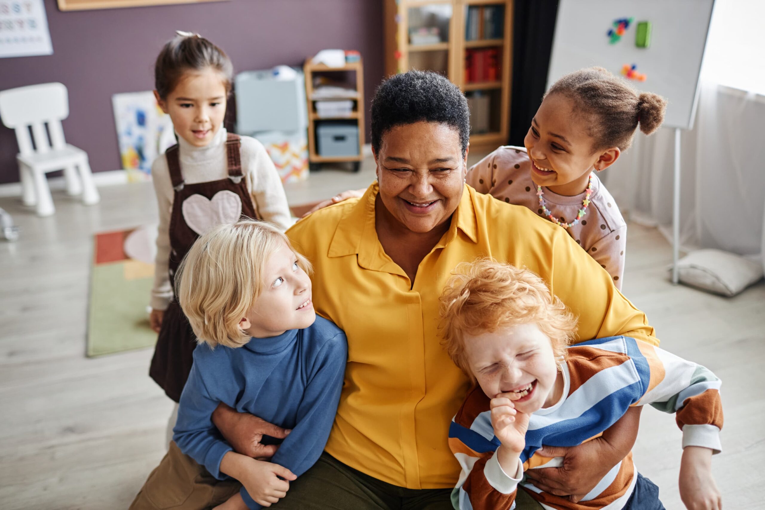 attachment in early years - practitioner hugging children