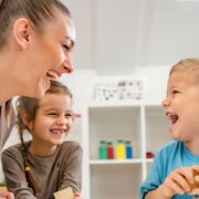 positive behaviour - children laughing at nursery with practitioner