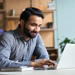 Man sat happy on laptop working from home