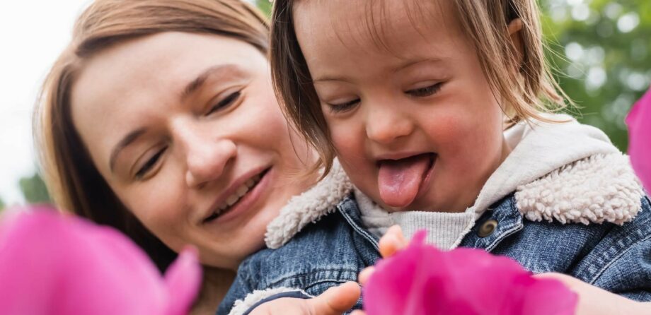 Child and practitioner looking at pink flower