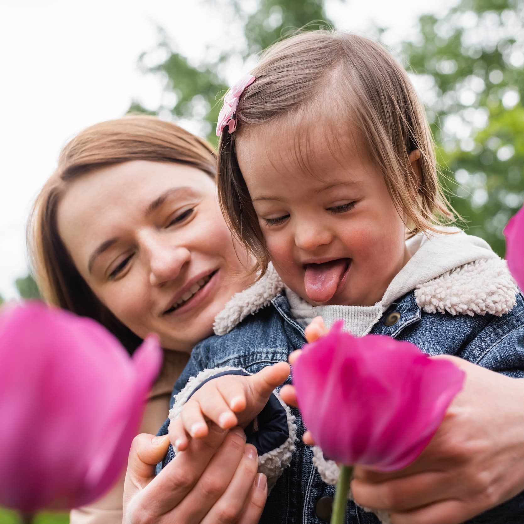 Child and practitioner looking at pink flower